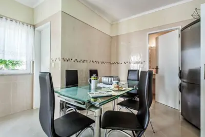 a dining room with a glass table and black chairs at Villa Girassol in Galé