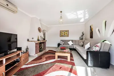 a living room with a couch and a tv at Villa Girassol in Galé