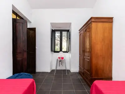 a room with two beds and a window and a chair at Akivillas Loulé Holiday in Espargal