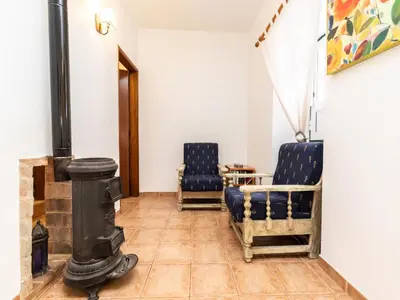 a room with two chairs and a wood stove at Akivillas Loulé Holiday in Espargal