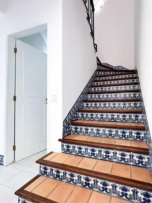 a staircase with blue and white tiles and a door at Villa Brasil by BeCherish in Quarteira