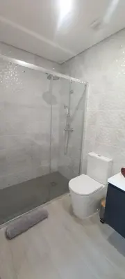 a bathroom with a white toilet and a sink at Almancil Residence in Almancil