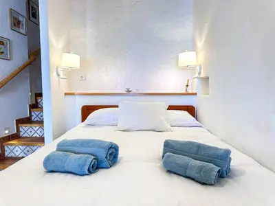 a white bed with two blue pillows on it at Charming AlgarvianOceanfront Townhouse by BeCherish in Albufeira