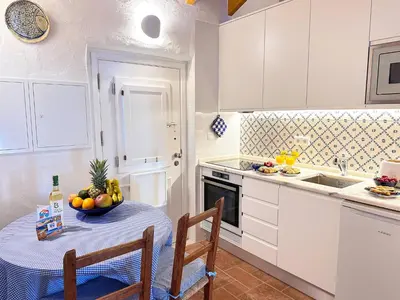 a kitchen with a table with a bowl of fruit on it at Charming AlgarvianOceanfront Townhouse by BeCherish in Albufeira