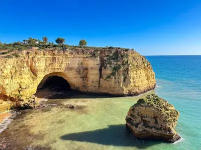 a large rock in the ocean with a tunnel in it at Charming AlgarvianOceanfront Townhouse by BeCherish in Albufeira