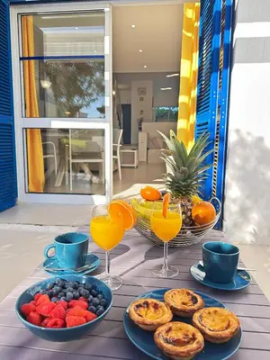 a table with plates of food and glasses of orange juice at Windmill Hill Cozy Townhouse by BeCherish in Albufeira