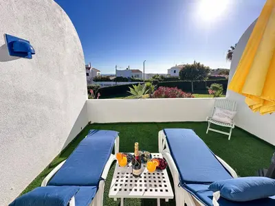 a small backyard with two beds and a table at Windmill Hill Cozy Townhouse by BeCherish in Albufeira