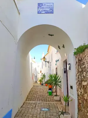an alley with an archway in a white building at Windmill Hill Cozy Townhouse by BeCherish in Albufeira