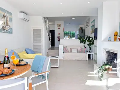 a kitchen and living room with a table and a couch at Windmill Hill Cozy Townhouse by BeCherish in Albufeira