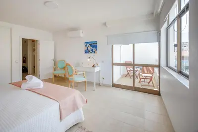 a bedroom with a bed and a table and chairs at Angela's in Albufeira