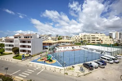 a tennis court in a parking lot in a city at Angela's in Albufeira