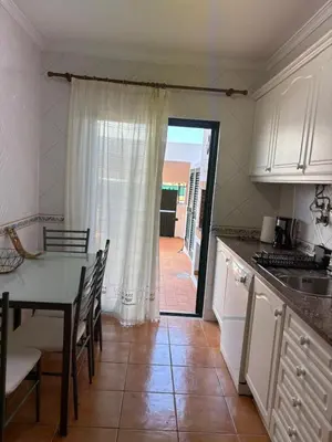 a kitchen with a table and a door to a patio at V3 Villa in Albufeira in Albufeira