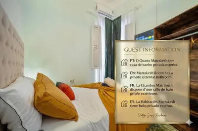 a bedroom with two beds with yellow and orange pillows at Vintage Senses Residences in Faro