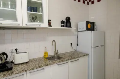 a kitchen with a sink and a white refrigerator at Moradia Mini Apartment in Faro
