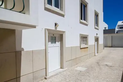 a white building with a white door and windows at Moradia Mini Apartment in Faro