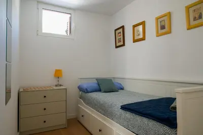 a bedroom with a bed and a dresser and a window at Moradia Mini Apartment in Faro