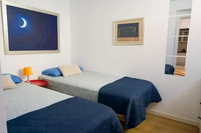 a room with two beds and a painting of the moon at Moradia Mini Apartment in Faro
