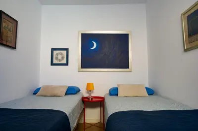 two beds in a room with a picture of the moon at Moradia Mini Apartment in Faro