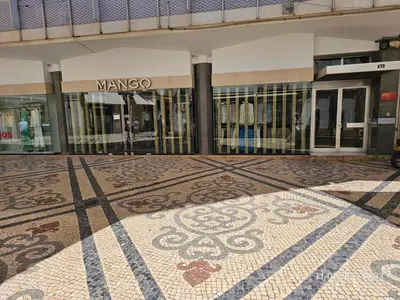 a building with a mosaic floor in front of a store at Blife Tonya - private rooms at Santantonya 1st floor in Faro
