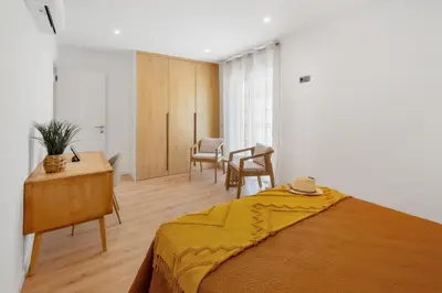 a dining room and living room with a wooden table and chairs at Mae Joana pool&beach Faro villa in Faro