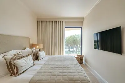 a bedroom with a large bed with a large window at Apartamento T2 renovado no Vila Sol com piscina in Vilamoura