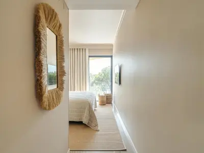 a hallway leading to a bedroom with a mirror at Apartamento T2 renovado no Vila Sol com piscina in Vilamoura
