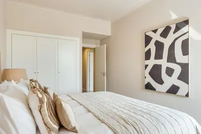 a bedroom with a bed and a painting on the wall at Apartamento T2 renovado no Vila Sol com piscina in Vilamoura