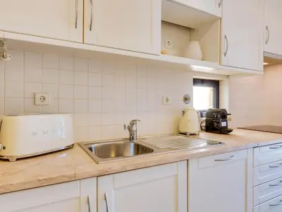 a kitchen with a sink and a counter top at Apartamento T2 renovado no Vila Sol com piscina in Vilamoura