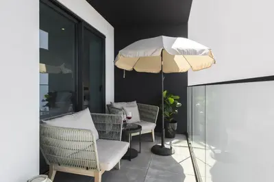 a patio with two chairs and an umbrella at Terracos de Quarteira II Cherry by Real Properties in Quarteira