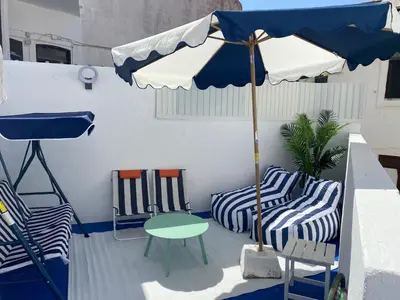 a patio with two chairs and a table and an umbrella at Blue Beach Home with Terrace in Albufeira