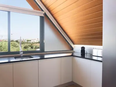 a kitchen with white cabinets and a window at Premium Apartment with Vilamoura Marina View in Vilamoura