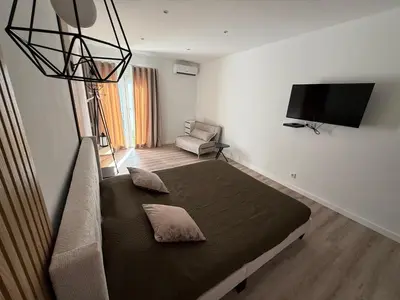 a bedroom with a bed and a couch and a television at Camilas place in Faro