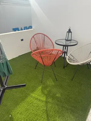 a table and two chairs and a table with green grass at Camilas place in Faro