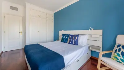 a bedroom with a bed with a blue wall at Cozy 1Bdr Flat w Pool in Vilamoura by Lovelystay in Quarteira