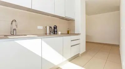 a kitchen with white cabinets and a sink at Cavalo Preto Ocean Breeze Apartment in Forte Novo Quarteira in Quarteira