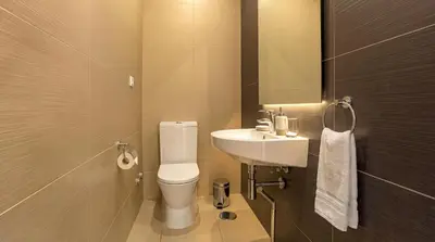 a bathroom with a sink and a toilet and a mirror at Cavalo Preto Ocean Breeze Apartment in Forte Novo Quarteira in Quarteira