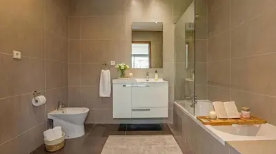 a bathroom with a sink and a toilet and a mirror at Cavalo Preto Ocean Breeze Apartment in Forte Novo Quarteira in Quarteira