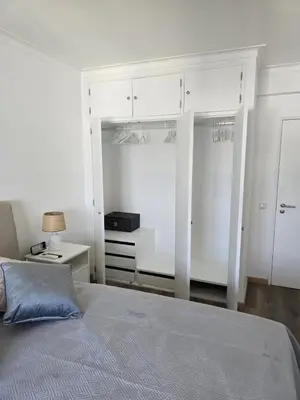 a bedroom with a bed and white cabinets at CityComfort in Faro