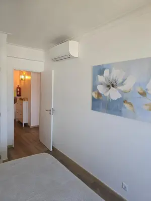 a bedroom with a painting of flowers on the wall at CityComfort in Faro