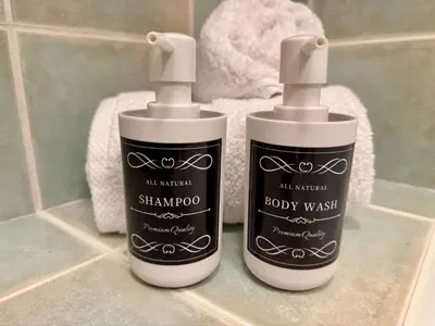 two bottles of shampoo sitting on a bathroom counter at Cosy 1-Bedroom Apartment with Private Terrace in Loulé in Loulé