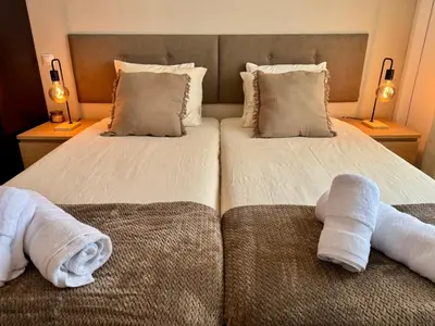 a hotel room with two beds with towels at Cosy 1-Bedroom Apartment with Private Terrace in Loulé in Loulé