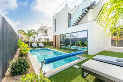 an exterior view of a house with a pool and a house at Villa Memorias by Algarve Holidays in Páteo
