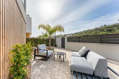 a patio with a couch and chairs on a balcony at Villa Memorias by Algarve Holidays in Páteo