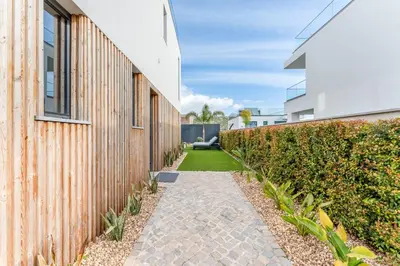 a walkway next to a building with a hedge at Villa Memorias by Algarve Holidays in Páteo