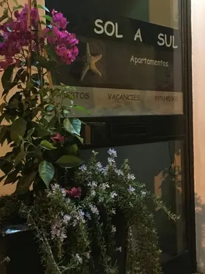 a sign on the side of a building with flowers at 150m to the beach at Sol a Sul apartments in Albufeira