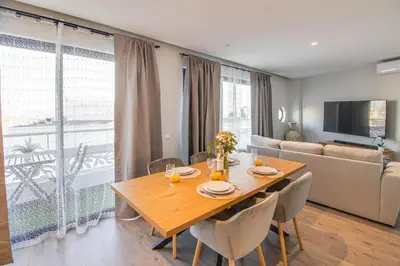 a dining room with a table and a couch at Stunning Ocean View Apt Beach 200mt AC Pool in Albufeira