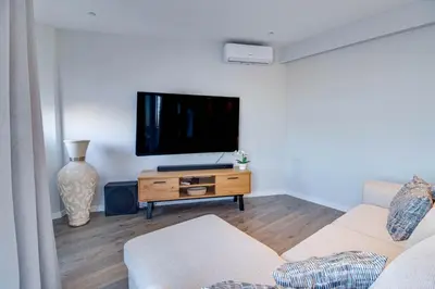 a living room with a couch and a tv on a table at Stunning Ocean View Apt Beach 200mt AC Pool in Albufeira