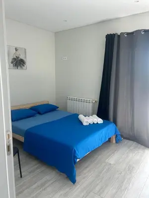 a bedroom with two beds with blue sheets and blue curtains at Luxury home in Albufeira in Albufeira