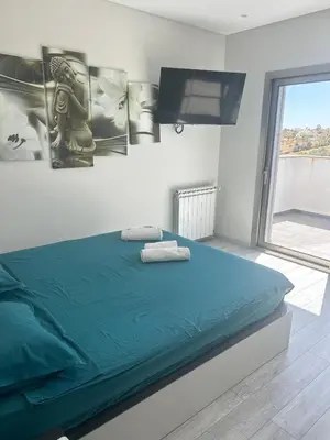 a bedroom with a bed with green sheets and a flat screen tv at Luxury home in Albufeira in Albufeira