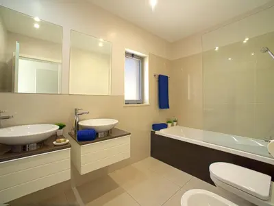 a bathroom with two sinks and a tub and a toilet at Apartment Pine Hills Jade by Interhome in Vilamoura